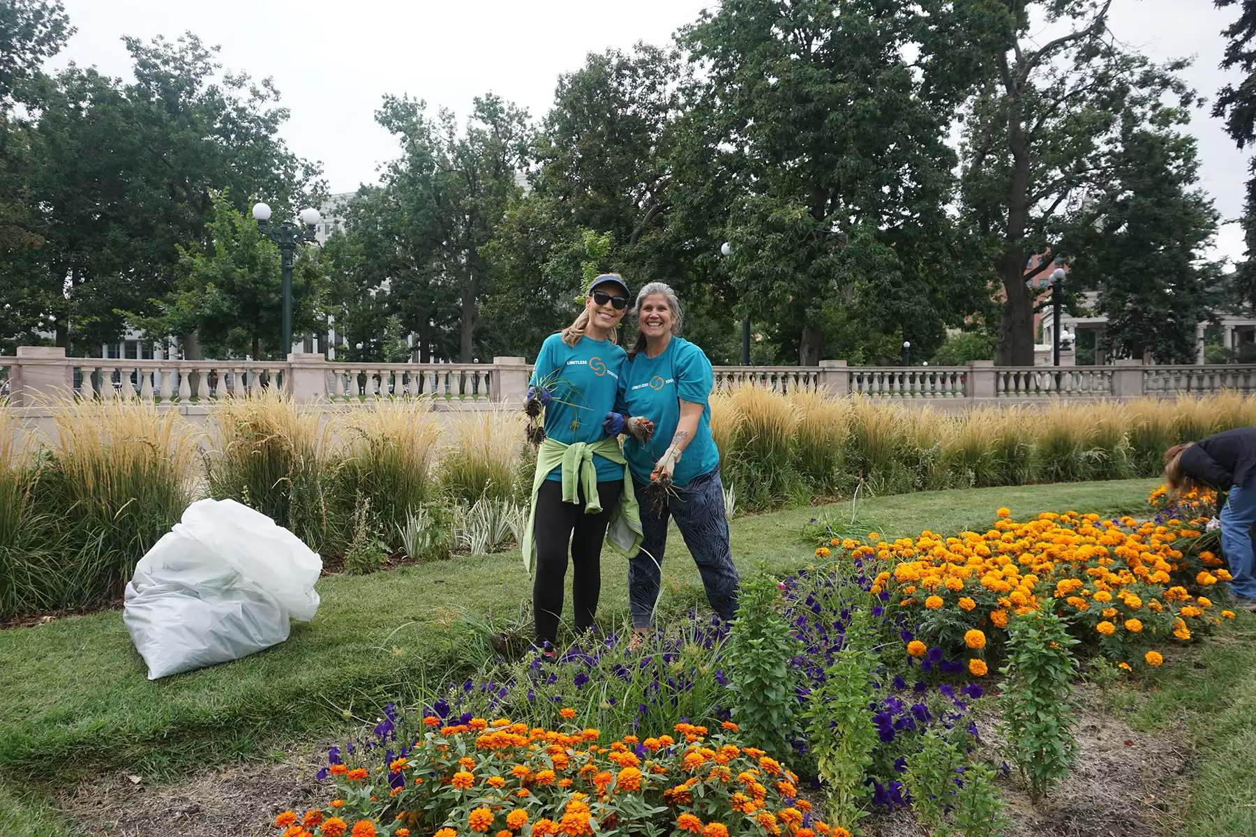 Two volunteers cleaning up the park, stopping to pose for a photo