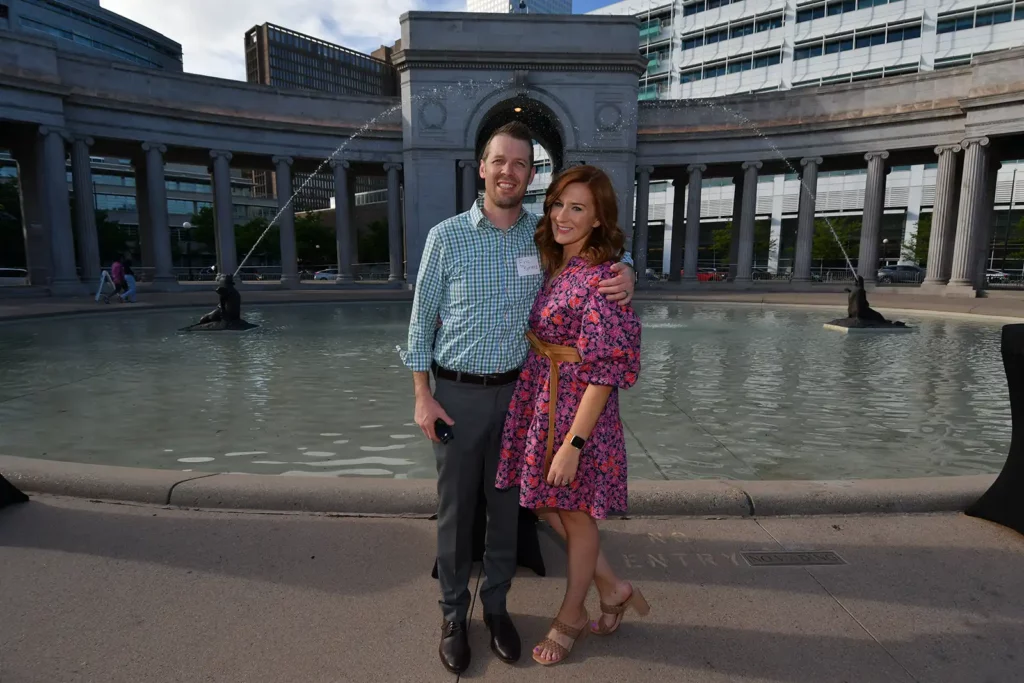 Photo of man and woman smiling together in front of fountains