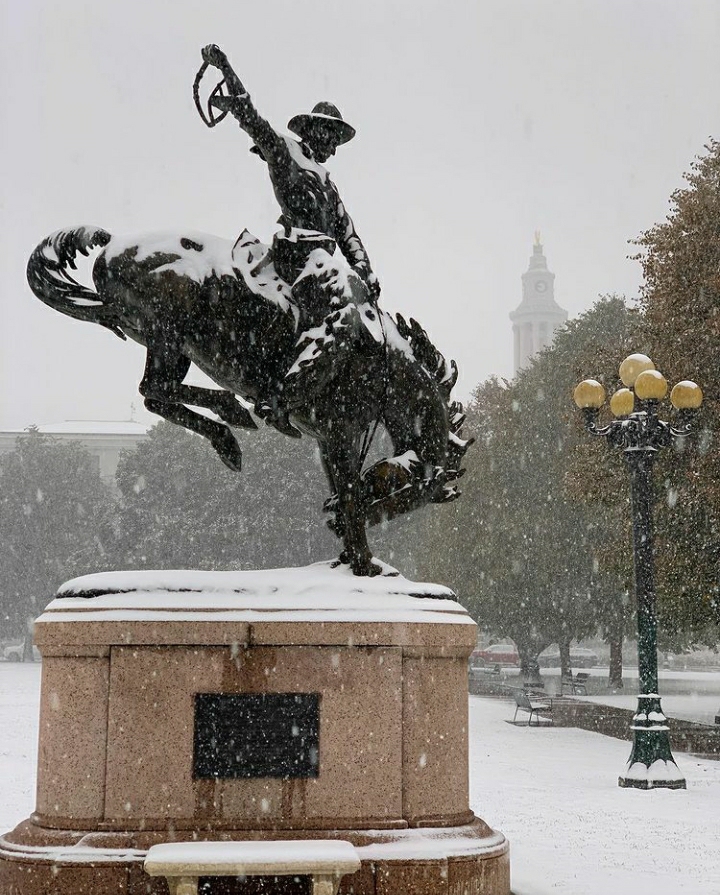 The Bronco Buster statue covered in a light dusting of snow